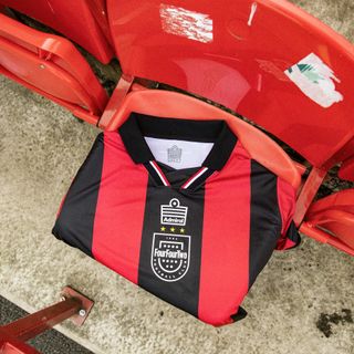 FourFourTwo's 30th anniversary football shirt made by Admiral draped over a red stadium seat