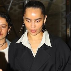 Zoe Kravitz in new york city wearing a black wrap coat and button down shirt