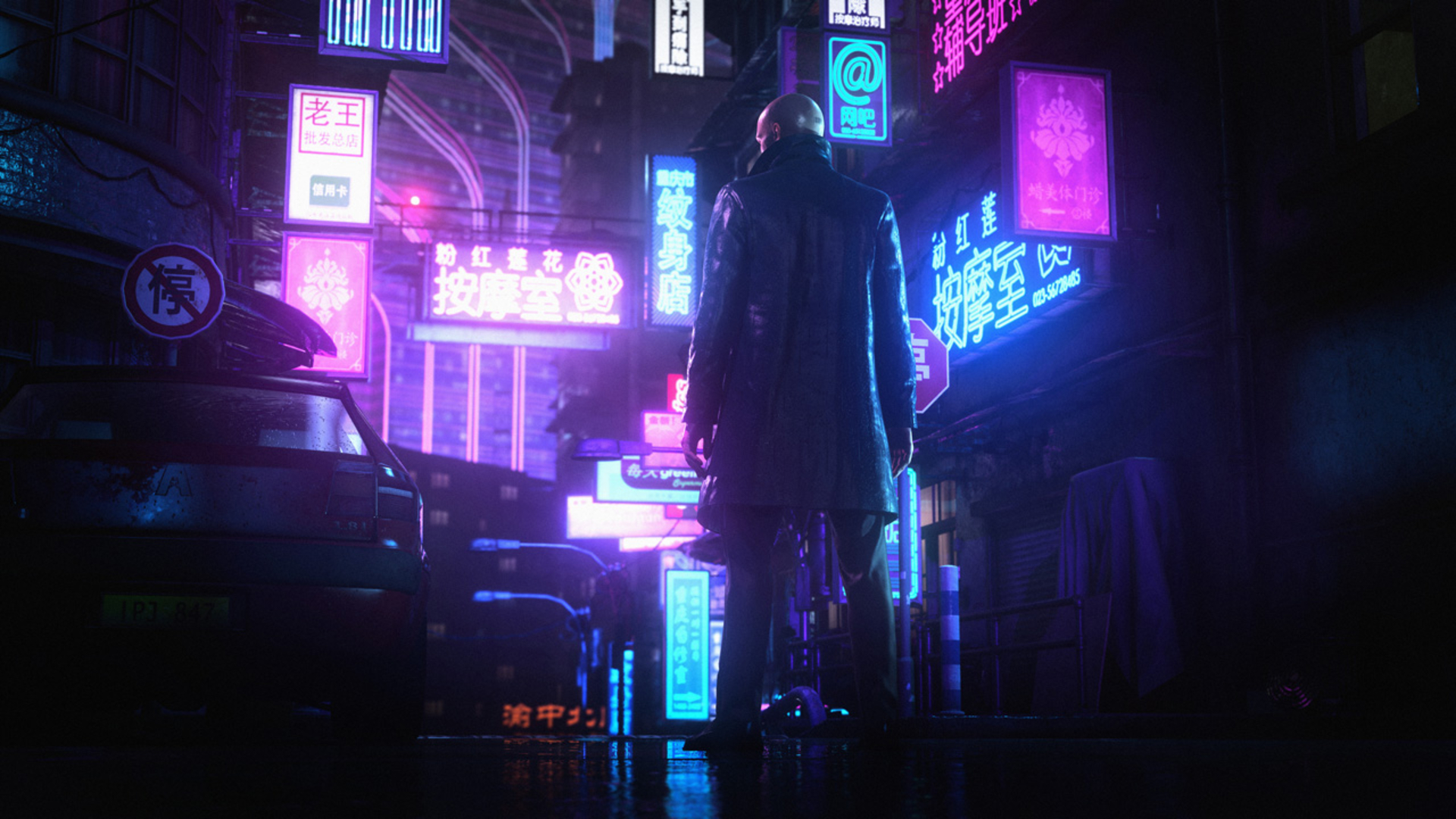 Agent 47 in a leather coat standing in a neon-lit city street in Hitman: World of Assassination