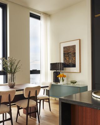 corner of the dining table with a blue sideboard against white walls