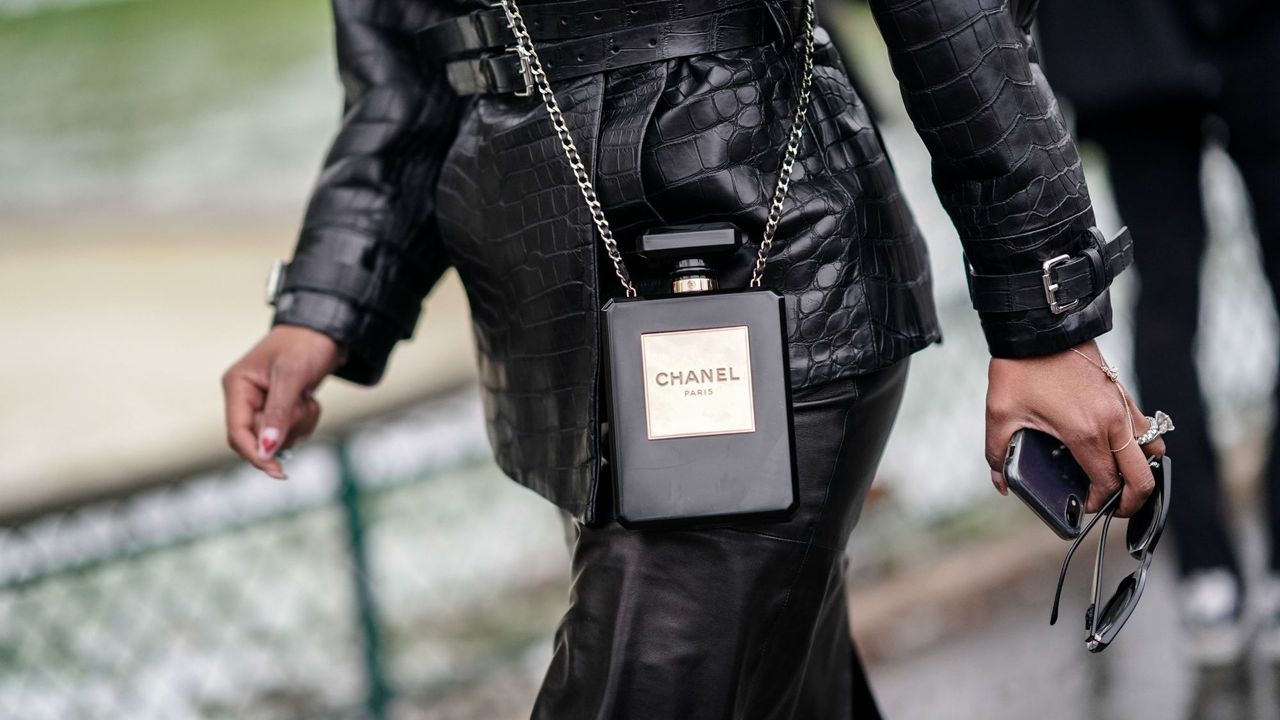 A woman wearing a leather outfit with a Chanel No5 handbag, one of the top perfumer fragrances