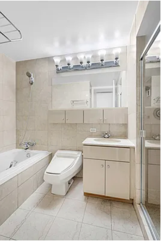 A dated bathroom with off-white tiles