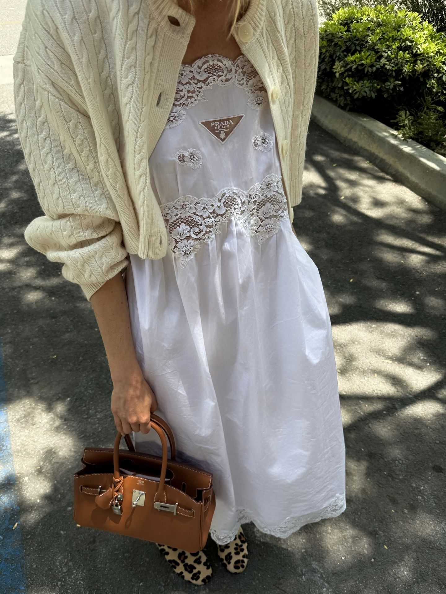 Elsa Hosk elevated her simple white cotton dress with a butter yellow cardigan and animal print shoes, giving it a decidedly summer 2025 energy.