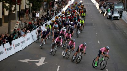 Image shows riders racing in a cycling crit race