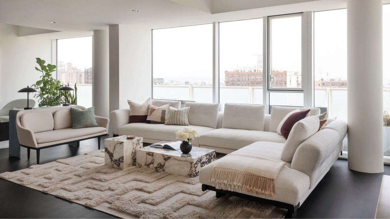 minimalist white living room with large white sofa and marble coffee table