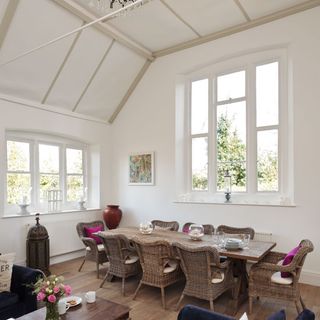 dining area with white wall and big window with dining table and chairs