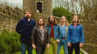 The Sheepdogs standing in front of a castle