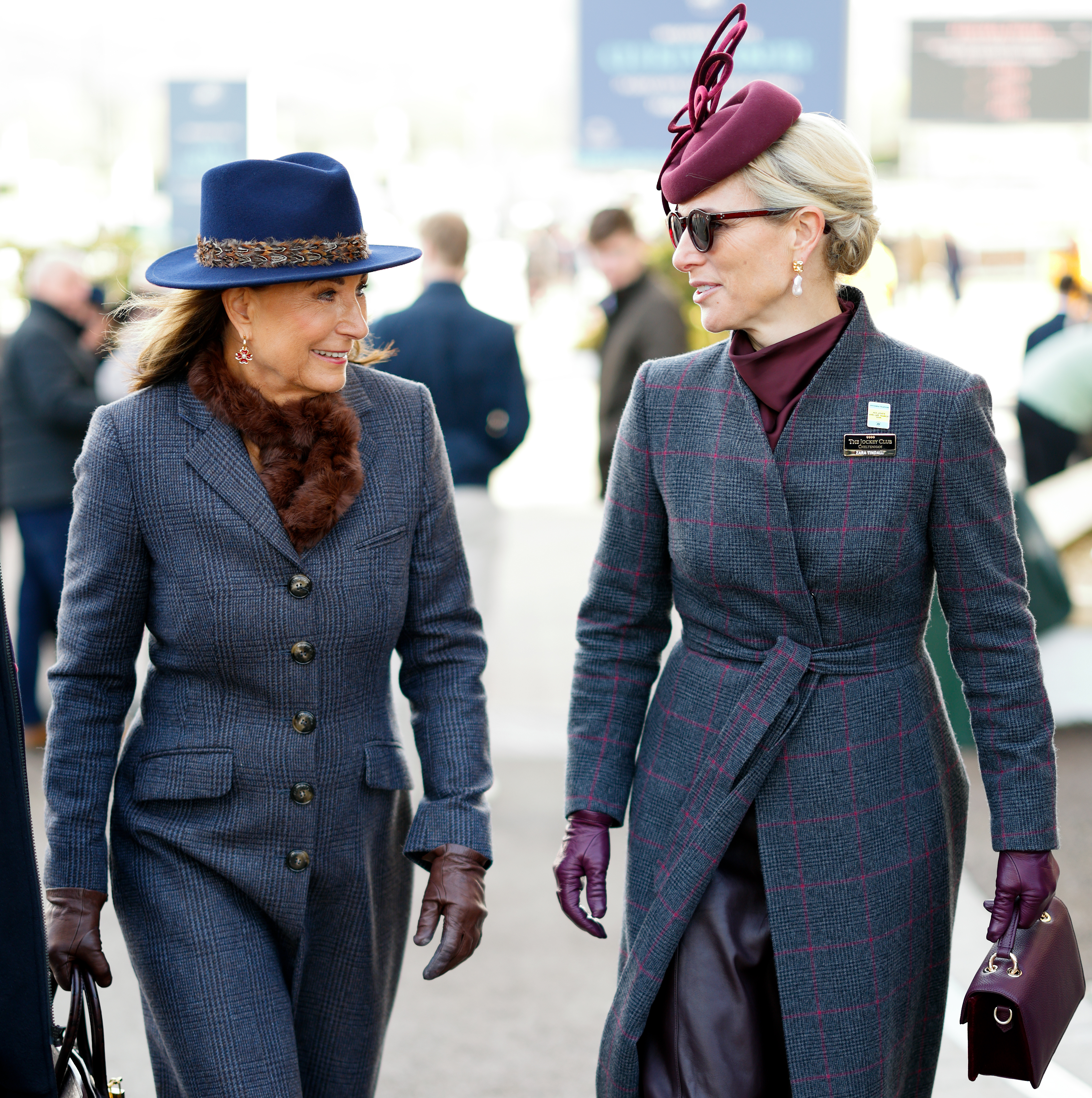 Carole Middleton and Zara Tindall walking next to each other in gray coats