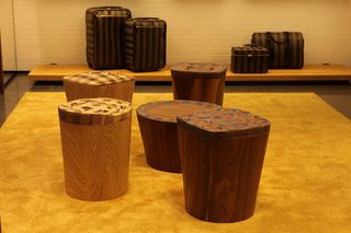 a collection of stools made of layers of wood and leather