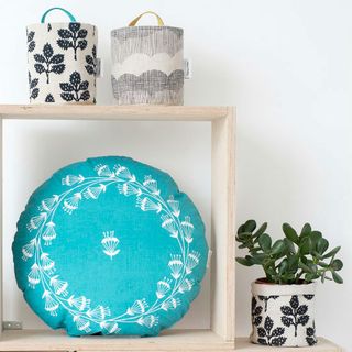 wooden shelve with pot and blue pillow