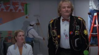 Robin Williams standing up in the middle of meeting, wearing a hi-tech jacket, in Toys.