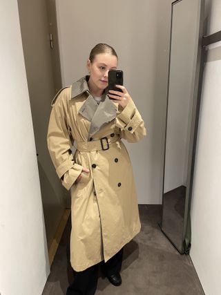 Woman wears COS trench coat