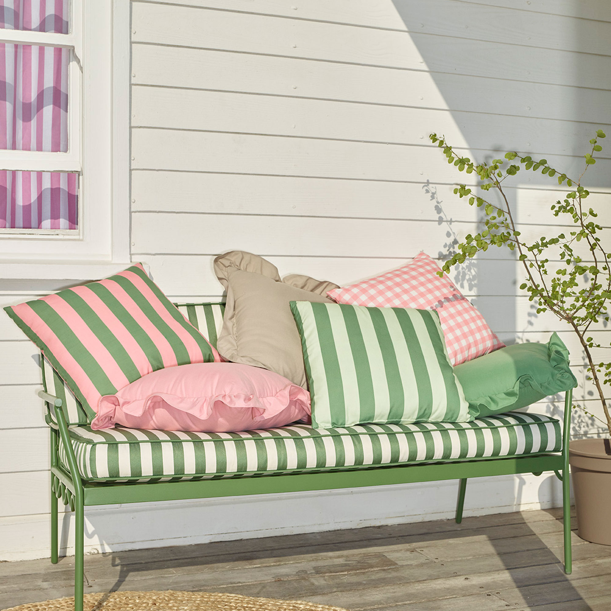 Green stripe bench piled up with striped cushions