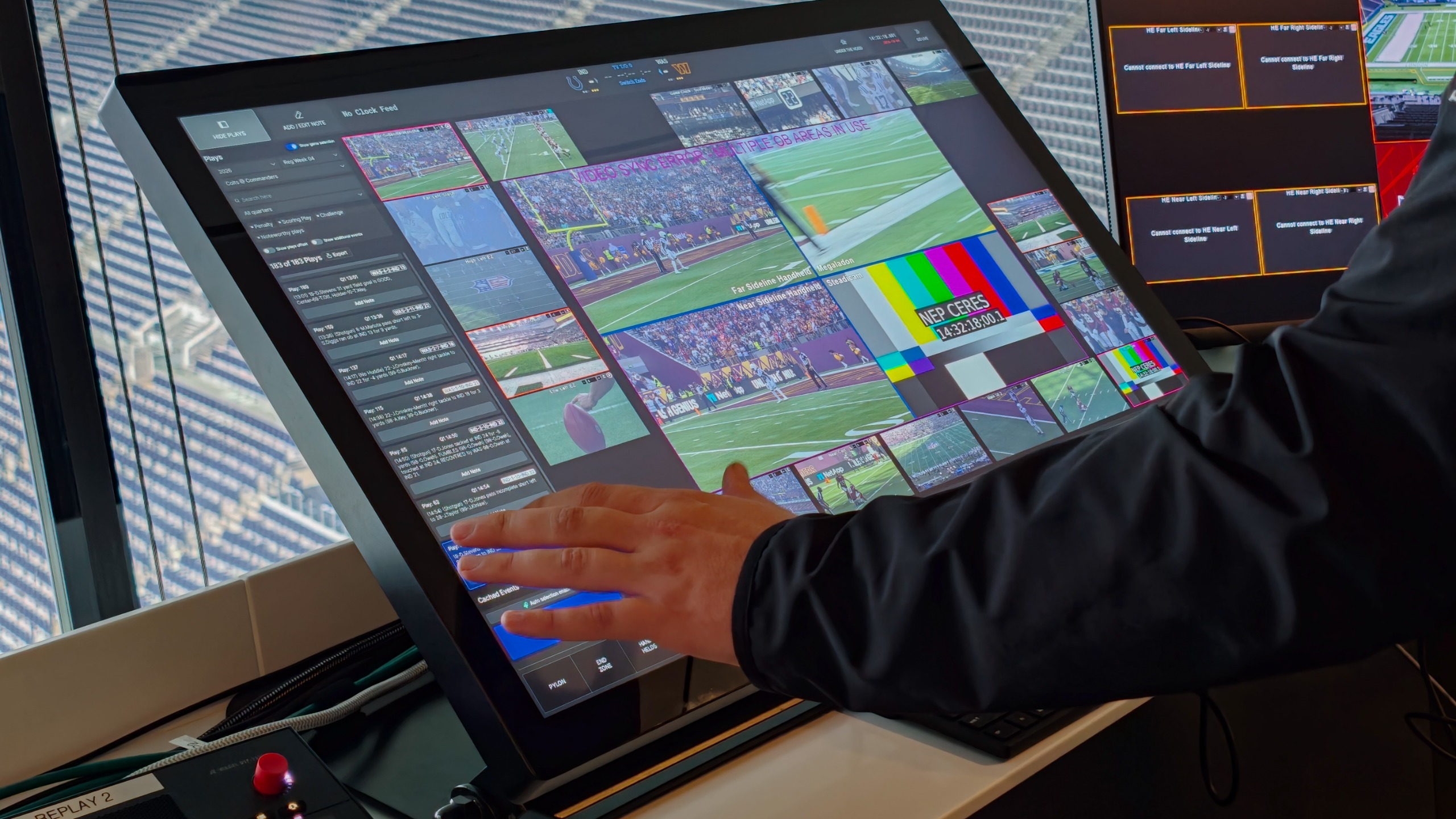 Operator using a large touchscreen display showing multiple live NFL camera feeds and replay controls.