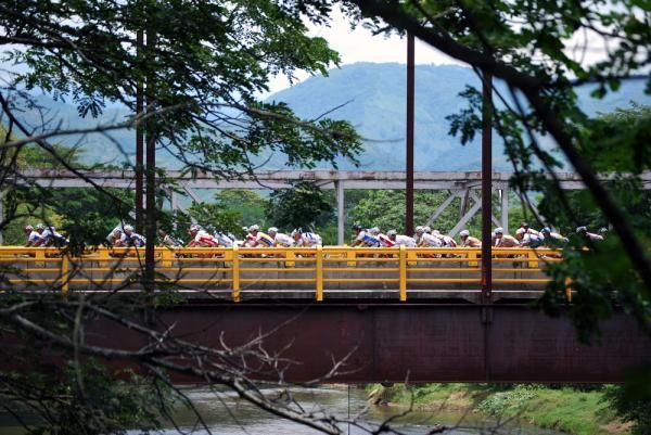 The peloton crosses a bridge early in the stage.