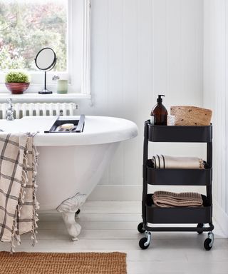 Ikea trolley used in bathroom for toiletry storage next to roll top bath