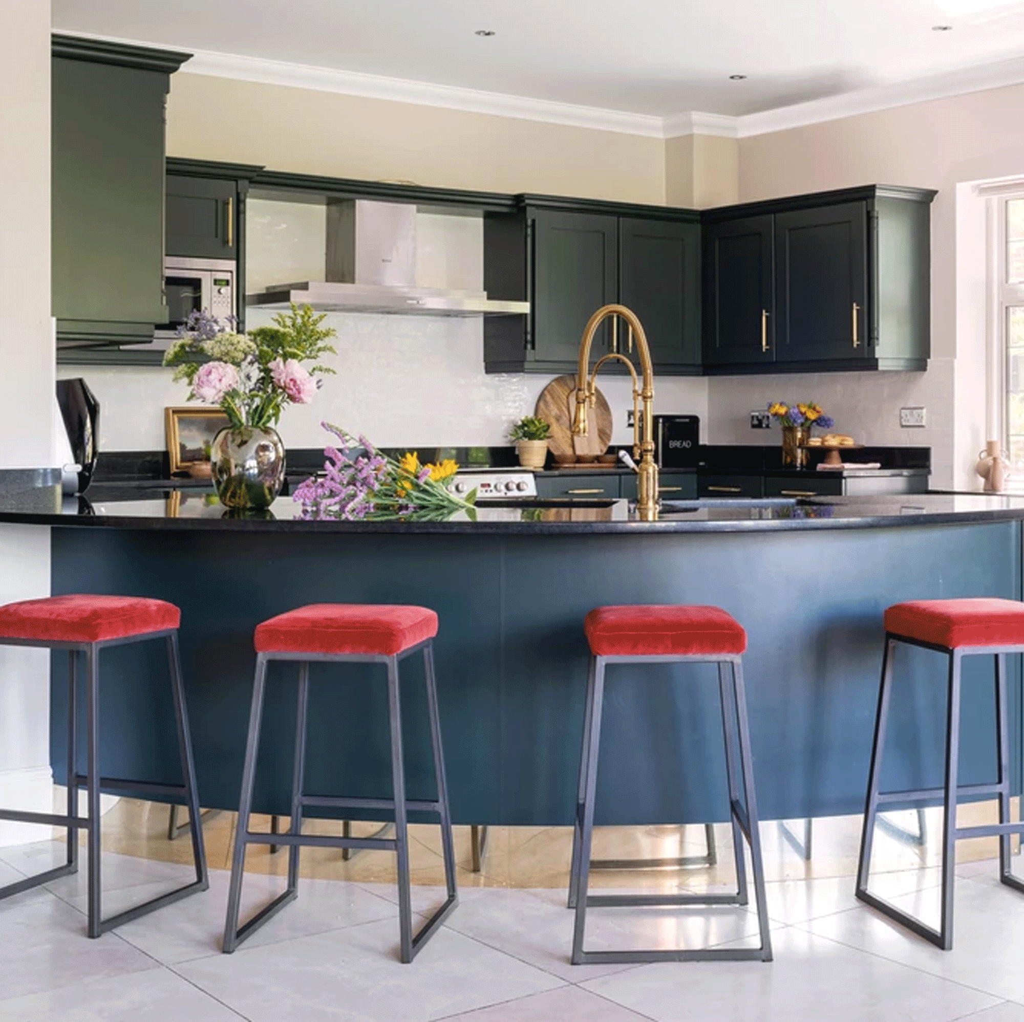 Blue curved kitchen island with red stools