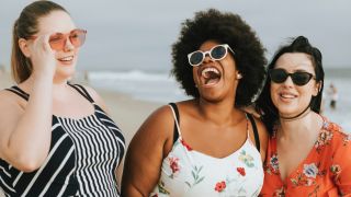Three women wearing sunglasses on the beach