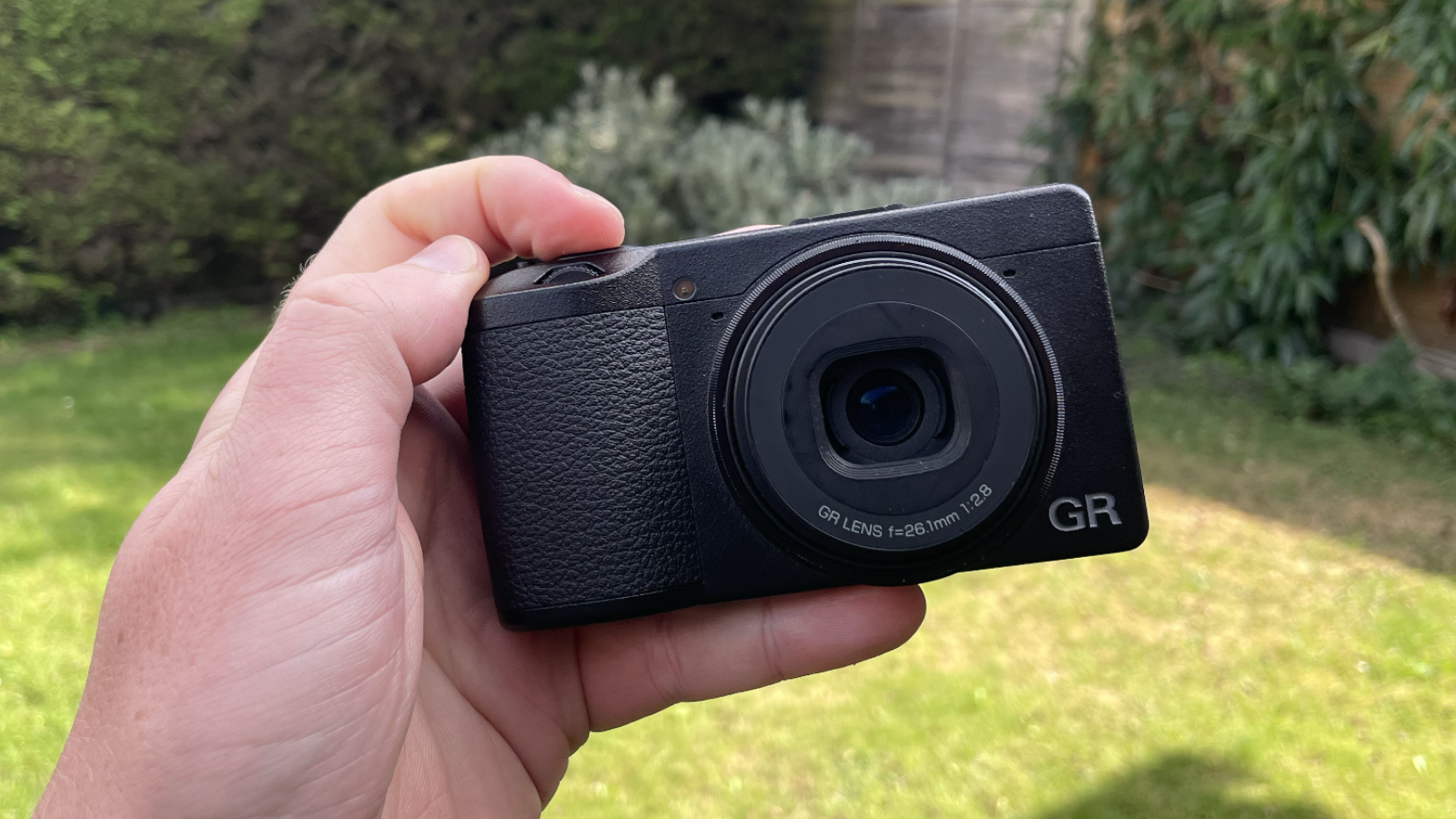 Ricoh GR IIIx HDF compact camera front side, in hand