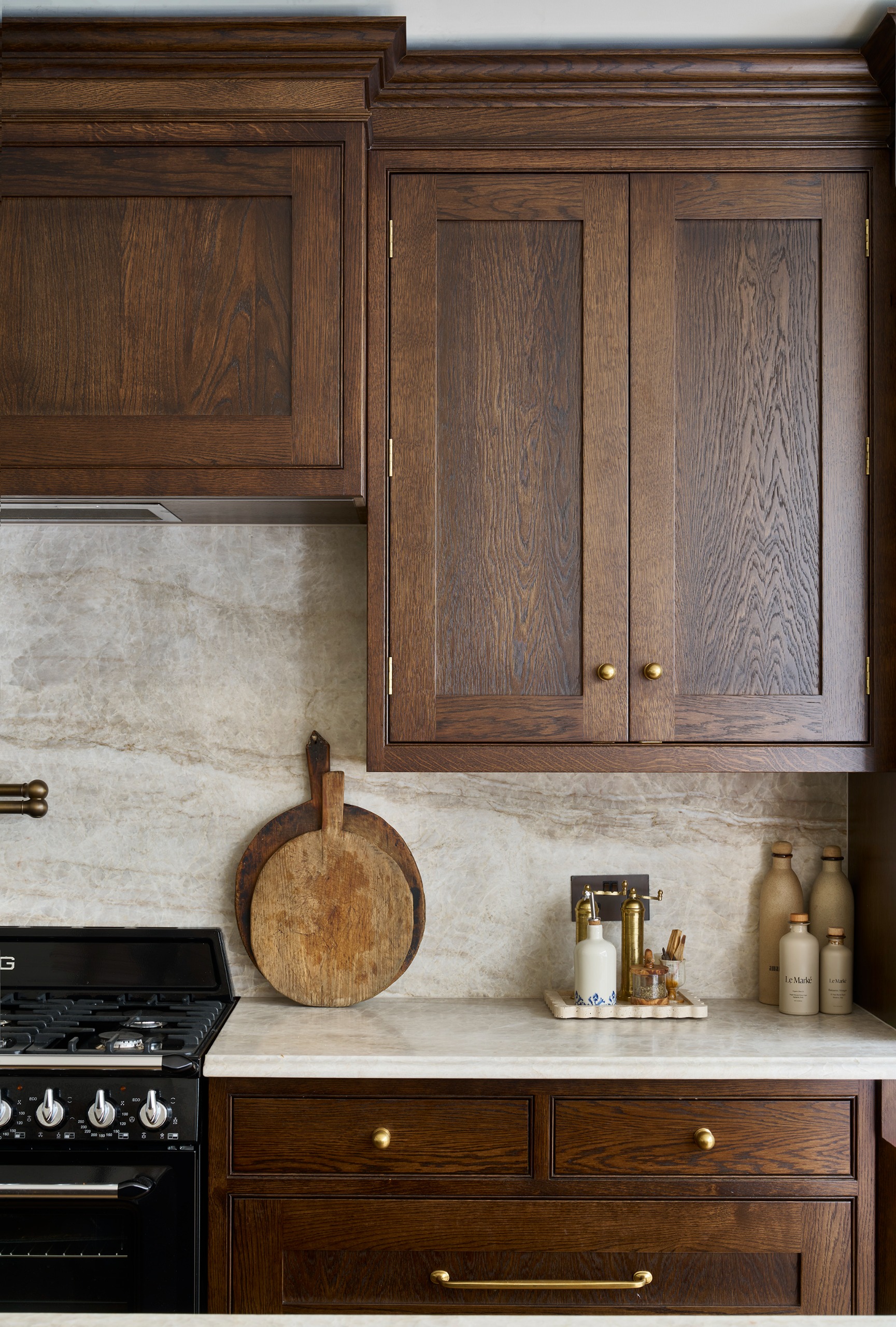 dark wooden cabinetry with bronze hardware, stone counters and antique decor items