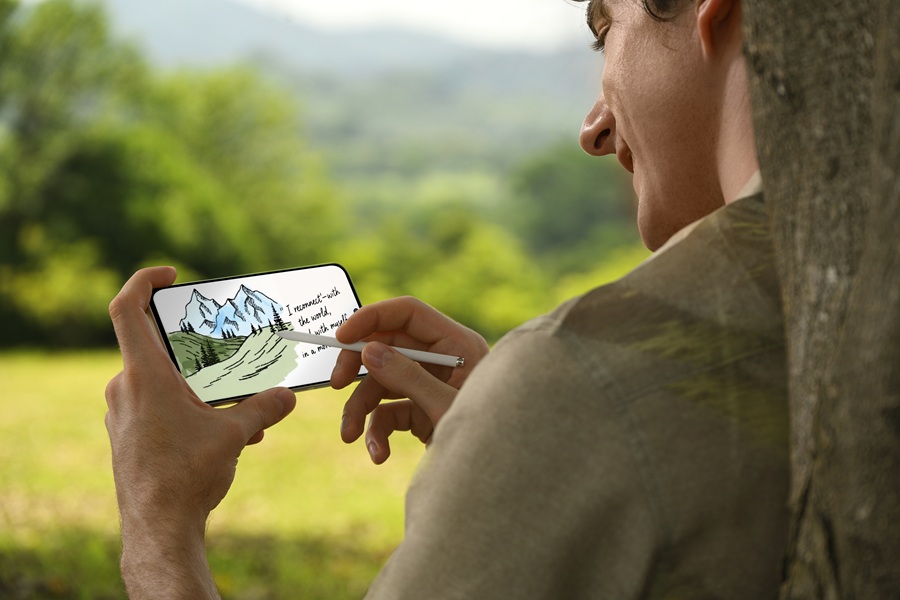 A model using the TCL NXTPAPER 60 Ultra and its stylus outside.