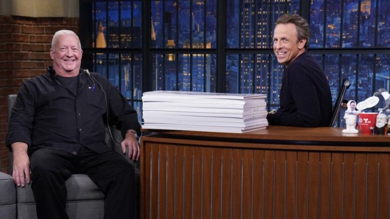 Cue card handler Wally Feresten and host Seth Meyers on October 2, 2023