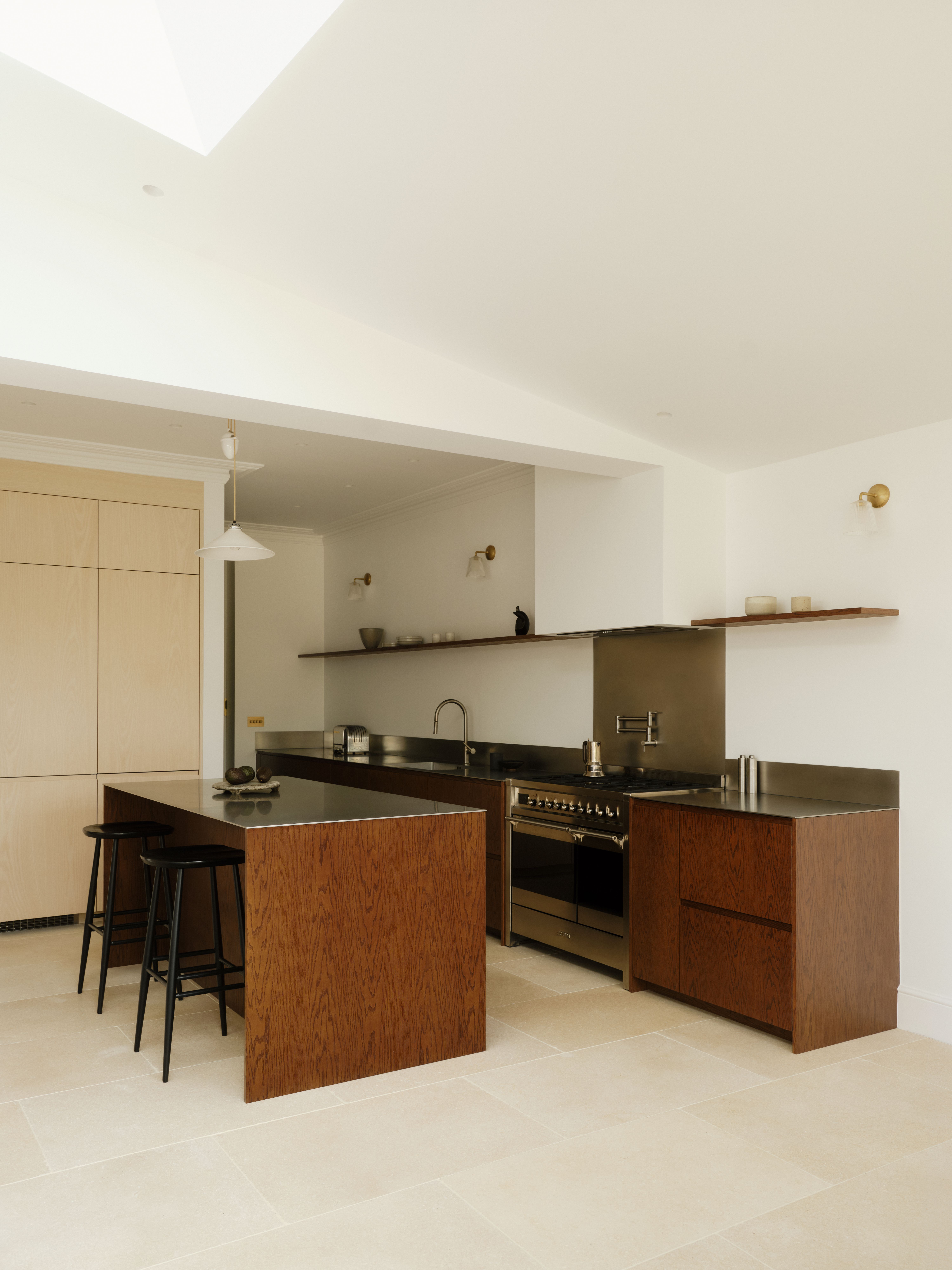 bright and light kitchen with dark timber cabinetry and stainless steel counters