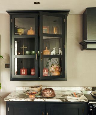 Black glazed kitchen cabinet filled with collectibles