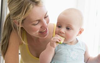 Weaning baby girl eating an apple