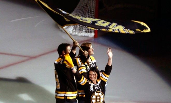 Relatives of Sean Collier, the MIT officer killed in the days after the Boston Marathon bombing, are cheered on the ice ahead of Game 3 of the Stanley Cup Finals.