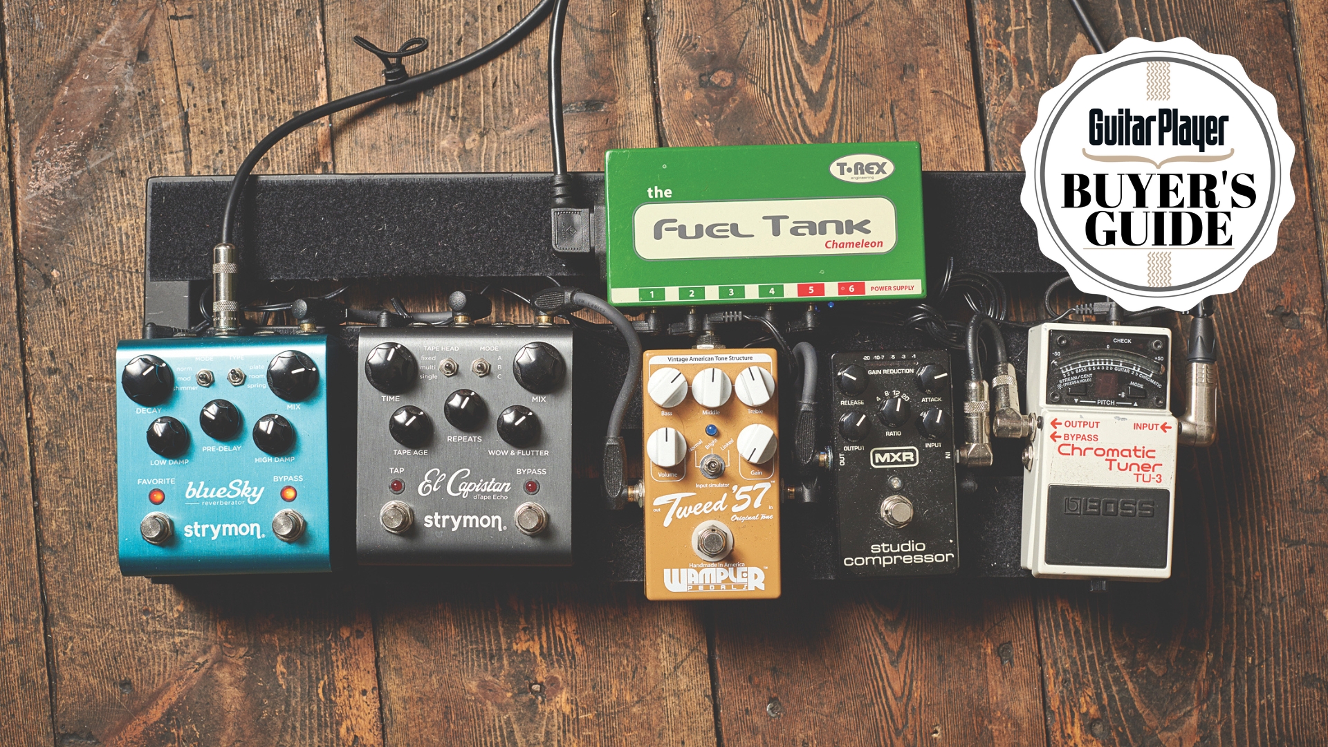 A pedalboard with guitar pedals on a wooden floor