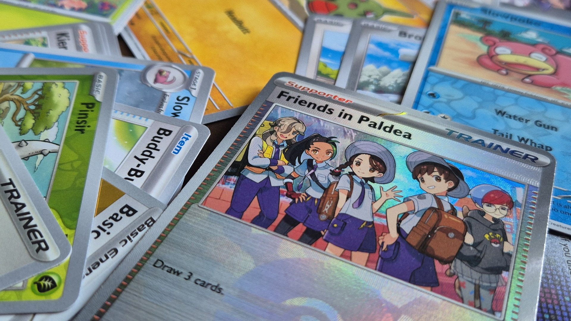 A selection of Pokemon Prismatic Evolutions cards laid out in a pile
