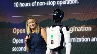 A presenter stands with the AGIBOT A3 on stage