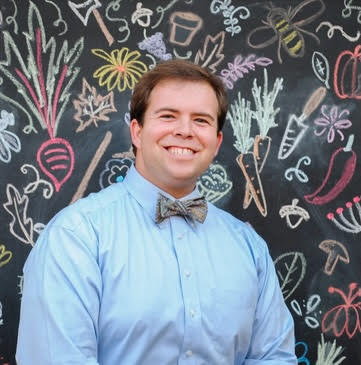 Headshot of man in blue shirt and bow tie
