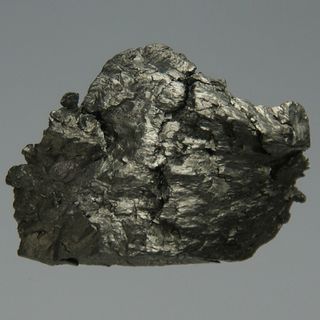 A small chunk of ultrapure amorphous gadolinium, 12 grams, about 1.5 x 2 cm.