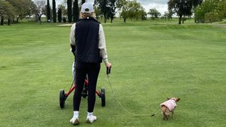 Lauren Katims walking with her dog on a fairway