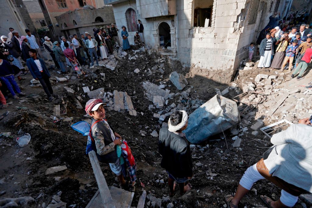 Yemenis in Saana look at wreckage from a Saudi bomb