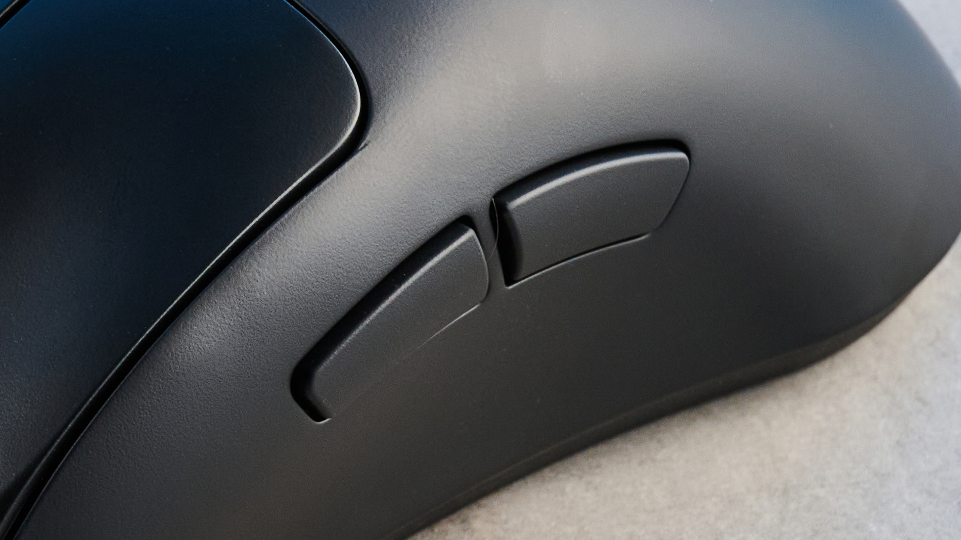 The SteelSeries Rival Pro mouse on a grey stone surface