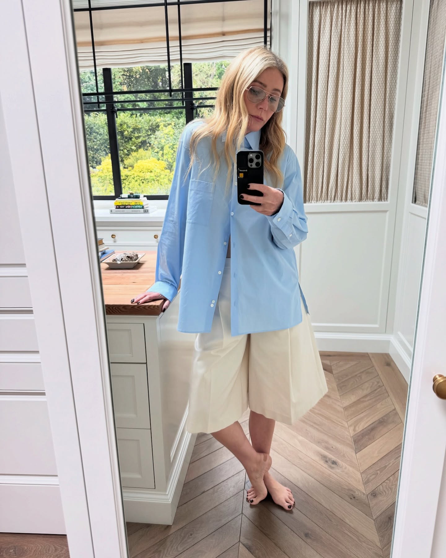 @gwynethpaltrow wears long cream Bermuda shorts with a blue linen shirt