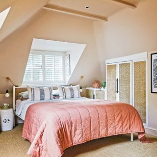 Peach bedroom loft conversion with large window and hessian flooring