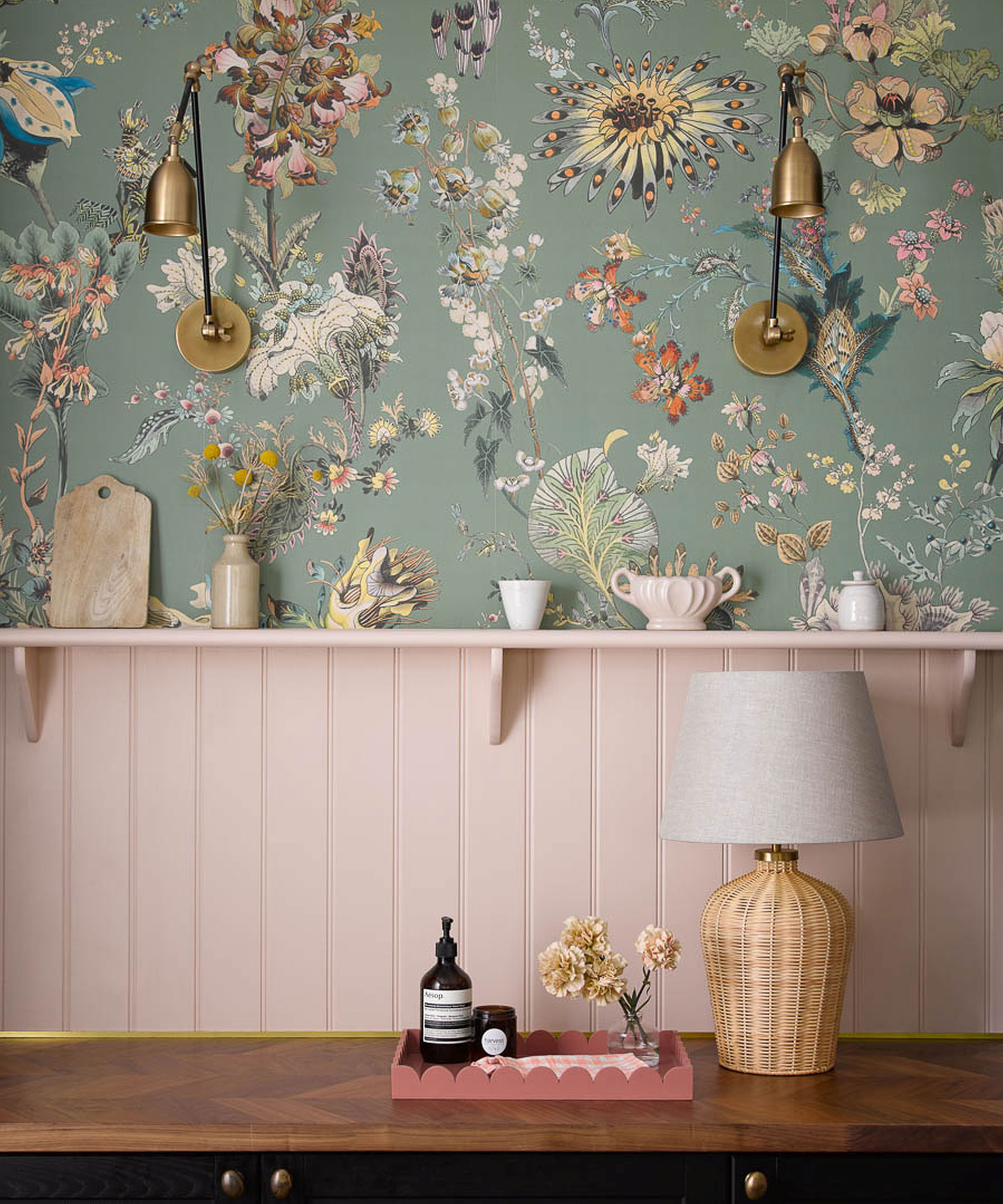 utility room with pink wall panelling and blue patterned wallpaper with brass wall lights