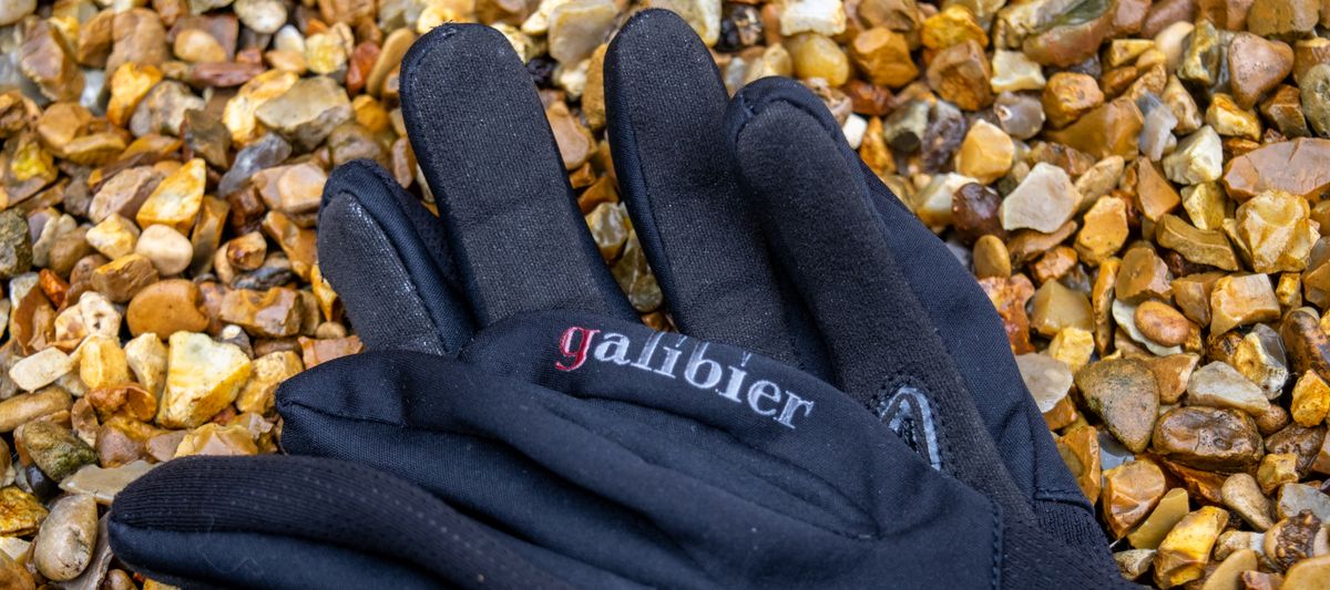 A pair of black Galibier Ardennes gloves on gravel 