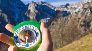 Person using compass to navigate in mountains