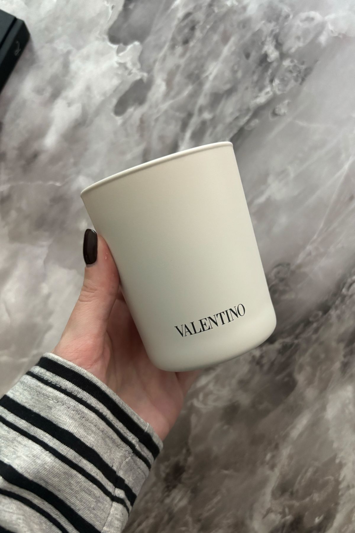 Deputy beauty editor Grace Lindsay holding the Valentino Cire Noire candle
