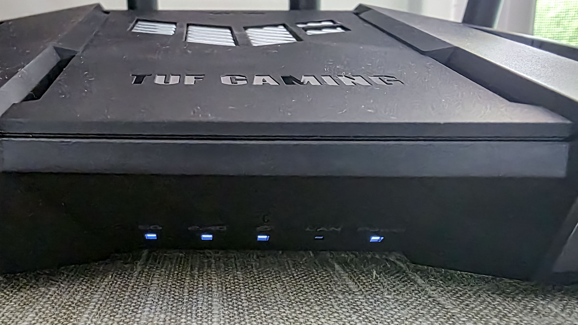 A close up view of the front of an Asus TUF Gaming BE6500 router.