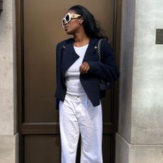 Influencer wears white jeans and black sandals.