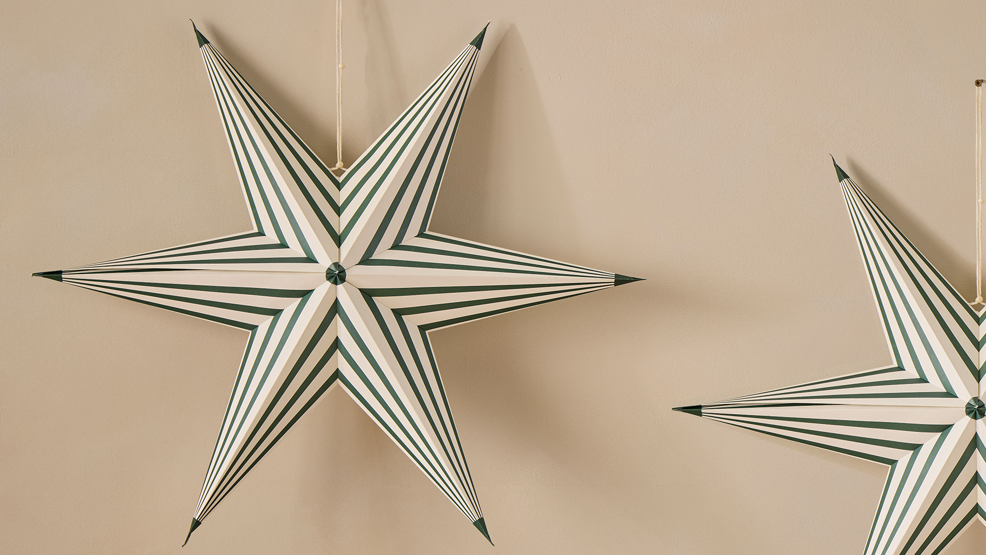 Green stripe star hanging on a beige wall