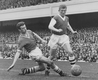 Chelsea's Peter Brabrook (left) slides in to tackle Arsenal's John Barnwell during a match in April 1959.