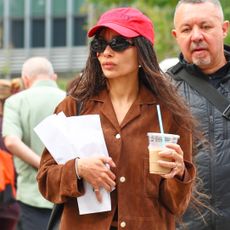Zo&euml; Kravitz wearing a red baseball cap, brown suede jacket, micro shorts, and ballet pumps in NYC