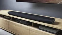the Denon S716H (HEOS Bar) on a light wooden cabinet
